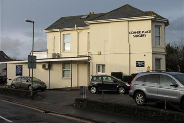 Cream two storey building, small car park with 3 parked cars